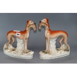 A pair of Victorian Staffordshire greyhound and hare groups height 28cm