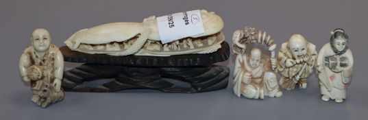 A Japanese ivory carving of a clam shell and four carved ivory netsuke