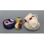 Two Moorcroft small vases, a lidded jar and four cups and saucers