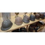 Seven various WWI and WWII helmets