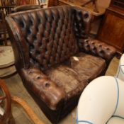 A leather button back high back two seat settee W.135cm