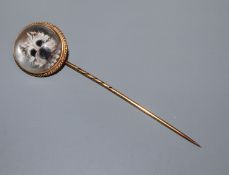 A late Victorian yellow metal and Essex crystal stick pin, decorated with the head of a terrier,