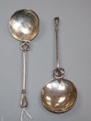 A pair of Arts and Crafts white metal serving spoons, with pierced scroll stems and openwork