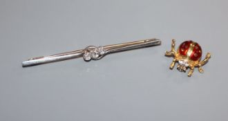 A 1920's 15ct, plat and three stone diamond bar brooch and an Italian 18k and enamel ladybird