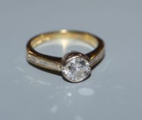 A modern 18ct gold and collet set single stone diamond ring, with baguette cut diamond set