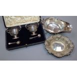 A George V silver sauceboat, a pierced silver bonbon dish and a cased pair of silver salts.