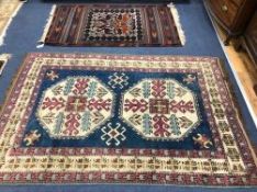 A Turkish blue ground rug with stylised motifs to ivory medallions and geometric borders and a Kilim