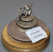 A silver trophy lid, modelled with a figure bowling (a.f.), now mounted on a wooden stand.