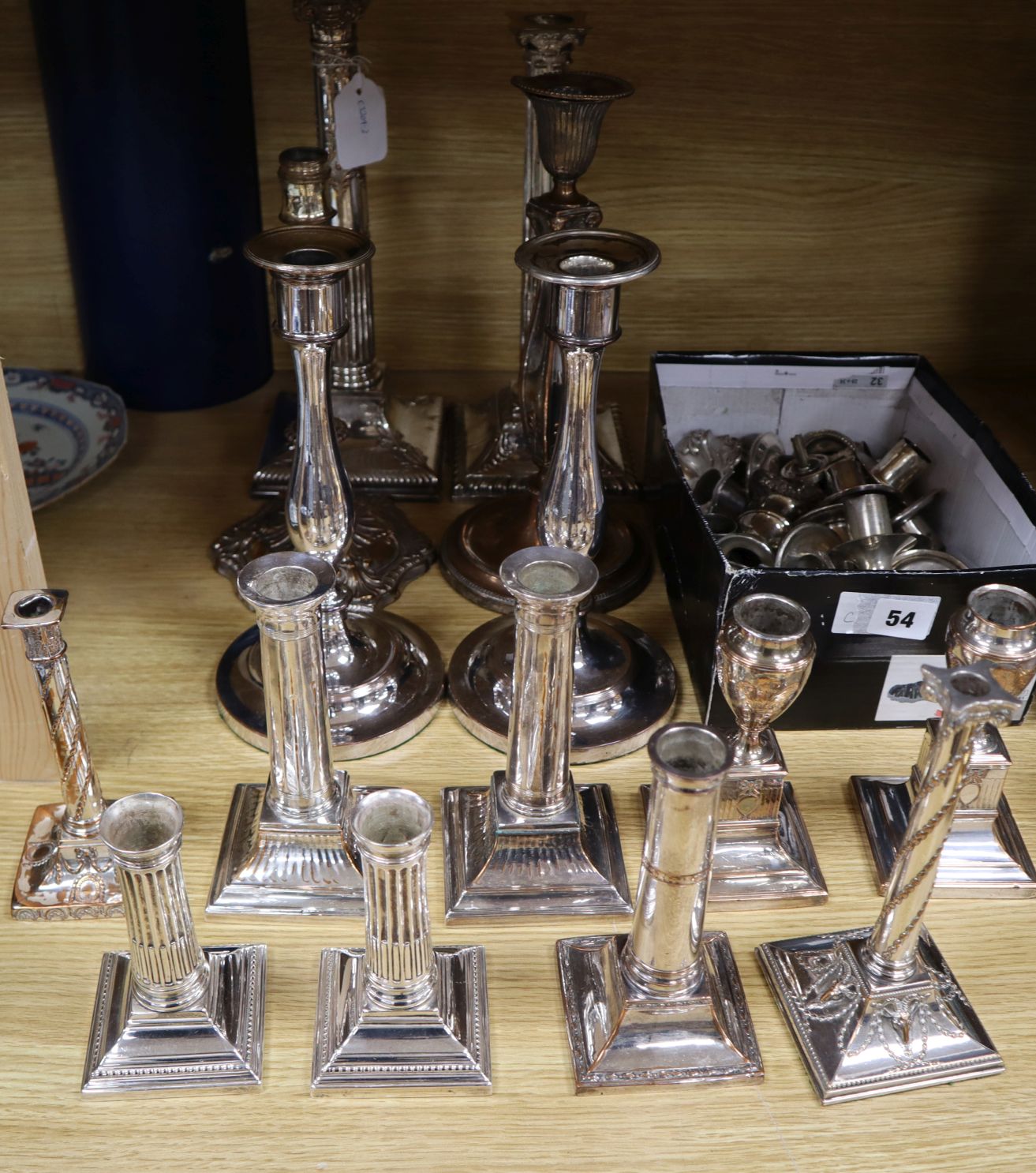 Four pairs of silver plated candlesticks, seven singular and sconces