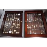 A collection of 48 souvenir spoons, plated, enamelled, etc. in two glazed display cases