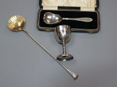 A cased silver spoon, a modern Asprey & Co stirring spoon with shell bowl and a white metal egg