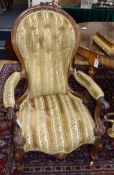 A Victorian carved walnut open armchair (a.f.) and a Victorian carved walnut nursing chair