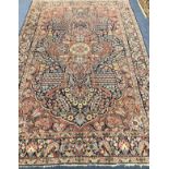 A Central Persian carpet with floral figured red ground central medallion on an all-over floral