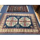 A Turkish blue ground rug with stylised motifs to ivory medallions and geometric borders and a Kilim