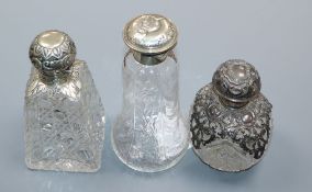 Three assorted Edwardian repousse silver mounted cut glass scent bottles, including Reynold's