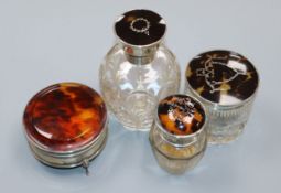 A George V silver and tortoiseshell mounted glass scent bottle, two similar toilet jars and a 1920's