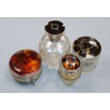 A George V silver and tortoiseshell mounted glass scent bottle, two similar toilet jars and a 1920's