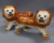 A pair of Staffordshire pottery figures of lions, 1910 width 32cm