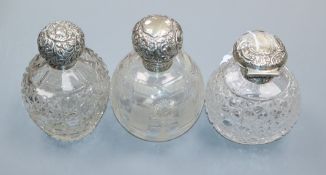 Three assorted late Victorian and later repousse silver mounted cut scent bottles including Mappin &