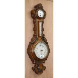 A late Victorian oak aneroid barometer, thermometer and timepiece H.89cm