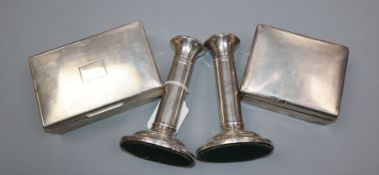 A pair of modern silver pillar candlesticks and two silver cigarette boxes.