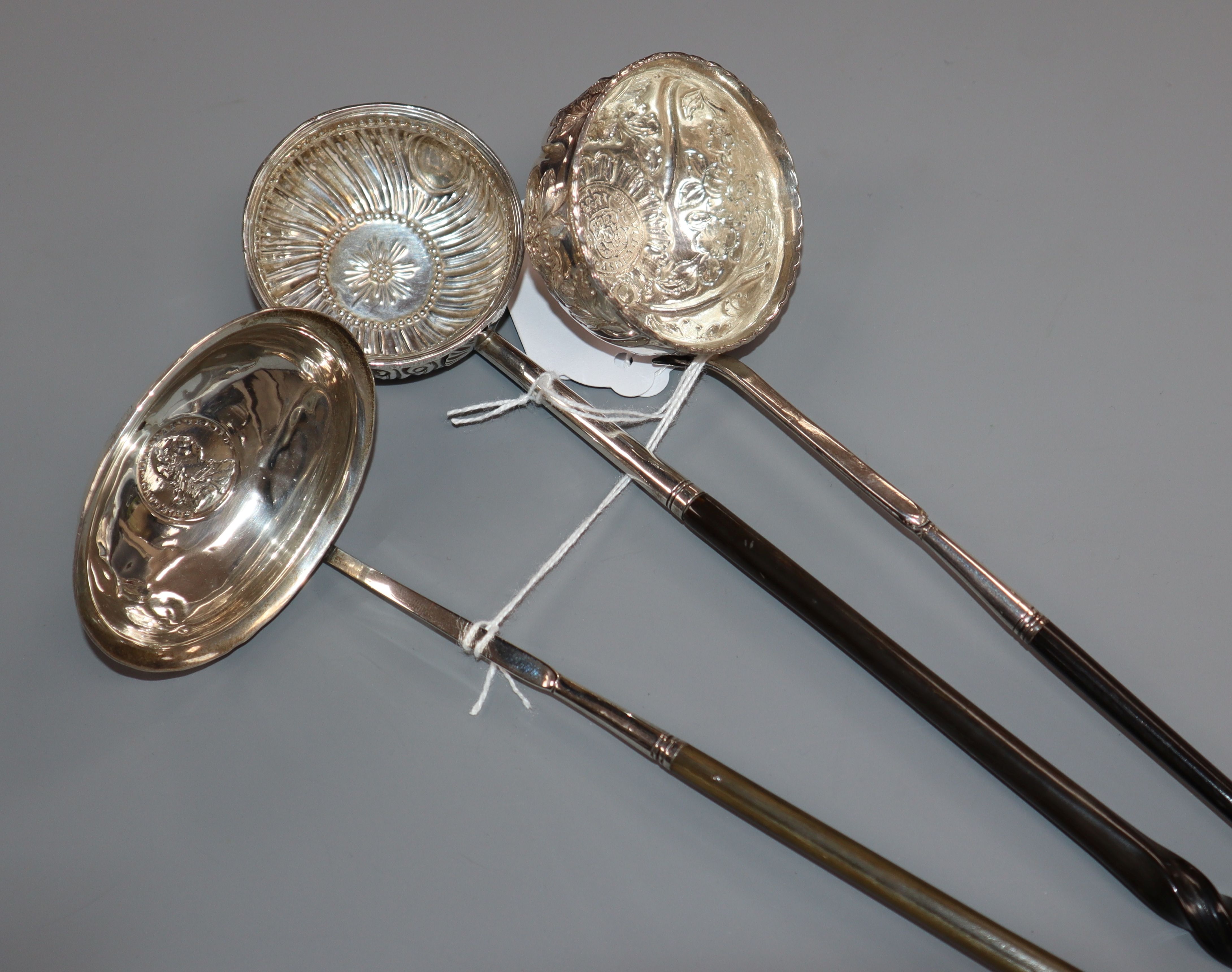 A Georgian coin-set toddy ladle with plain oval bowl and whalebone handle and two other toddy ladles