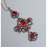 An early-mid 20th century white metal and garnet set quatrefoil shaped drop pendant, on a long