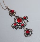 An early-mid 20th century white metal and garnet set quatrefoil shaped drop pendant, on a long