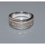A modern 750 white metal and three row round and princess cut diamond half hoop ring, size O.
