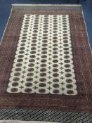 A Bokhara style ivory ground carpet 350 x 240cm