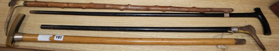 Four walking canes including horn and stag antler handles, three silvered collars