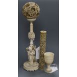 A Chinese carved ivory concentric ball on stand supported by a Buddha with lotus and two other ivory