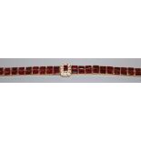 A modern yellow metal, garnet and diamond gold bracelet (tests as 18ct), 16.7cm.