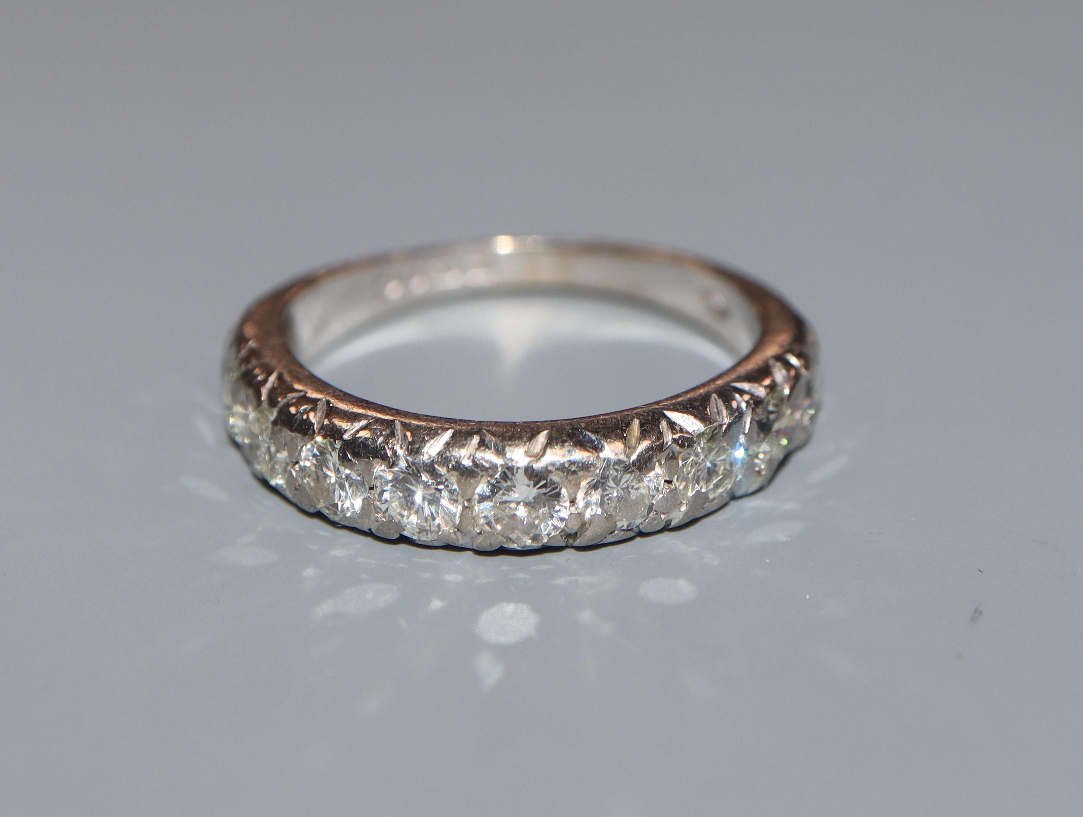 A modern 18ct white gold and ten stone diamond set half eternity ring, size L/M.