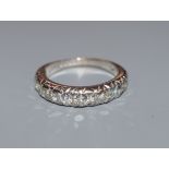 A modern 18ct white gold and ten stone diamond set half eternity ring, size L/M.