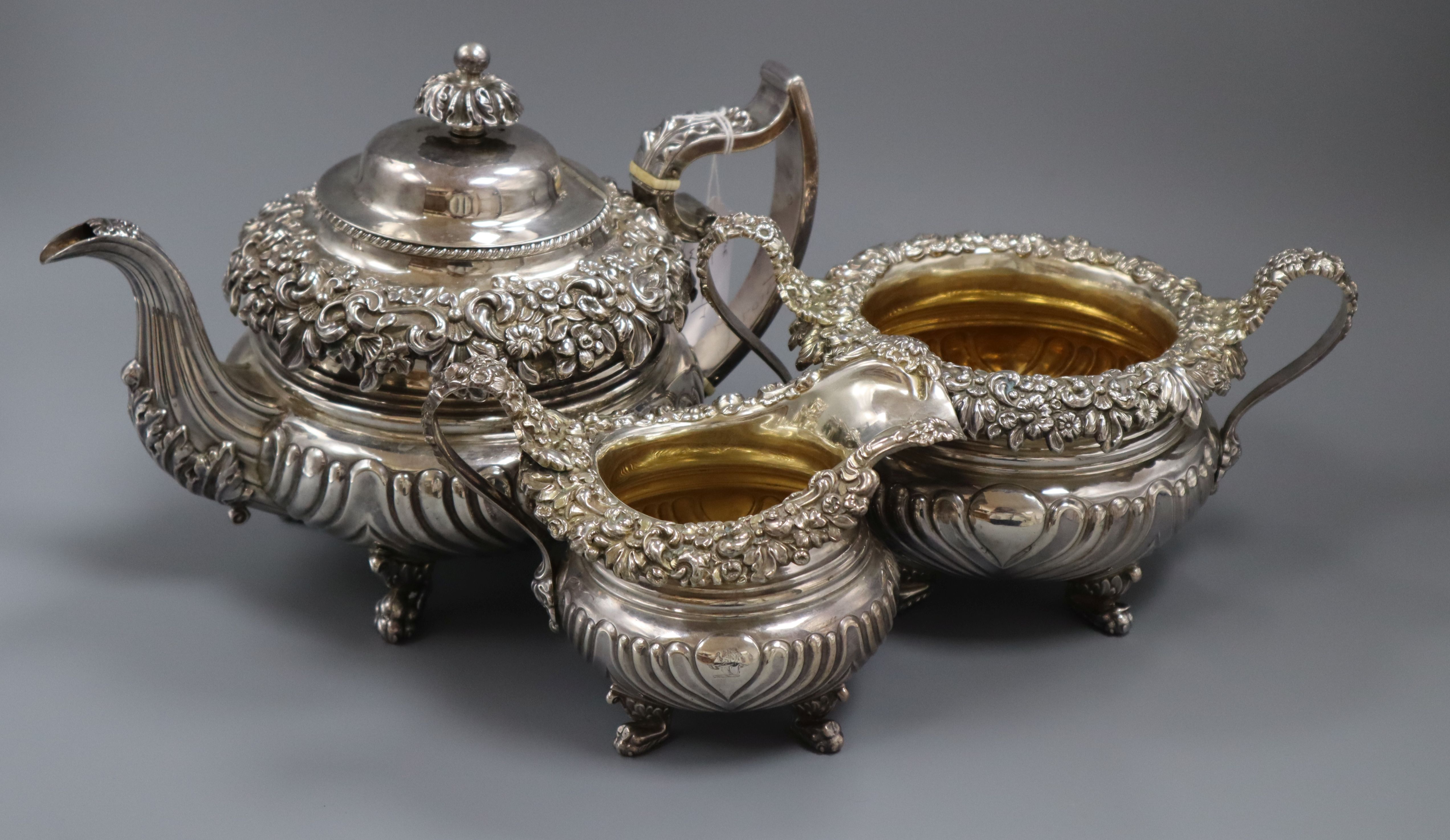 A George III three-piece silver and silver-gilt tea service, of circular half-fluted form with heavy