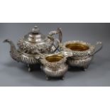 A George III three-piece silver and silver-gilt tea service, of circular half-fluted form with heavy