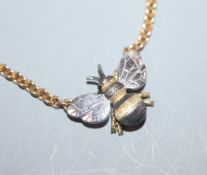 A yellow and white metal 'bee' pendant on 18ct yellow gold chain, gross 11 grams.