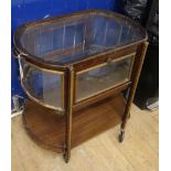 A two-tier drinks trolley of oval form, with glazed upper section and galleried undertier W.72cm
