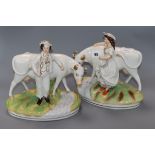 A pair of Staffordshire groups of a boy and girl with cows height 25cm