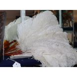 Two white ostrich feather fans, one with gold-monogrammed blond faux-tortoiseshell guard sticks