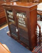 A late Victorian walnut two door bookcase, the doors later painted with the Frys chocolate logo W.