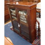 A late Victorian walnut two door bookcase, the doors later painted with the Frys chocolate logo W.