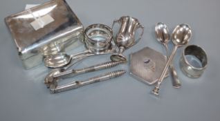 A silver cigarette box, silver pencil, two silver napkin rings, small silver trophy cup, five silver