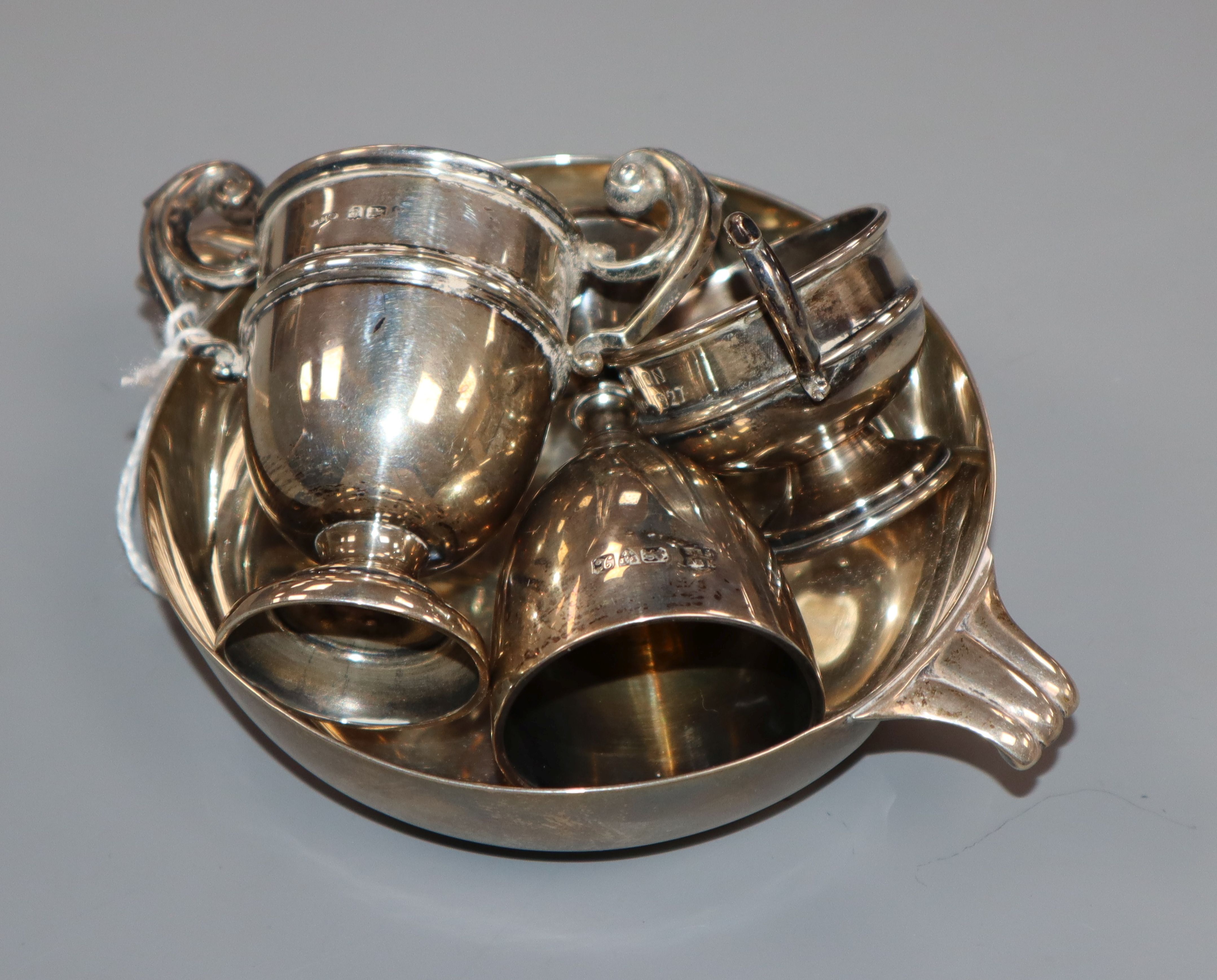 A silver quaich and three small silver trophy cups.