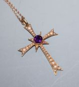 An Edwardian 15ct gold, amethyst and seed pearl set cross pendant, on a yellow metal fine link