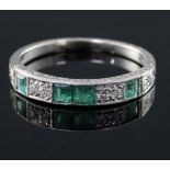 An 18ct and plat, emerald and diamond set half hoop ring, with engraved shank, size N.