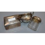 A George III silver sauce boat, a silver cigarette box and silver mounted glass toilet bottle.