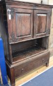 A 18th century Scottish oak Aumbry enclosed by a pair of panelled doors over an open shelf and