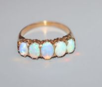 A yellow metal and graduated five stone white opal half hoop ring, size N.